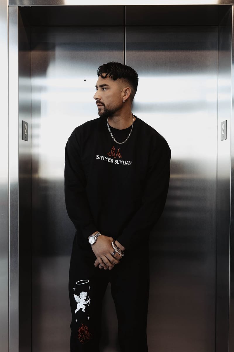 A model wearing the Sinner Sunday crewneck and cherub sweatpants